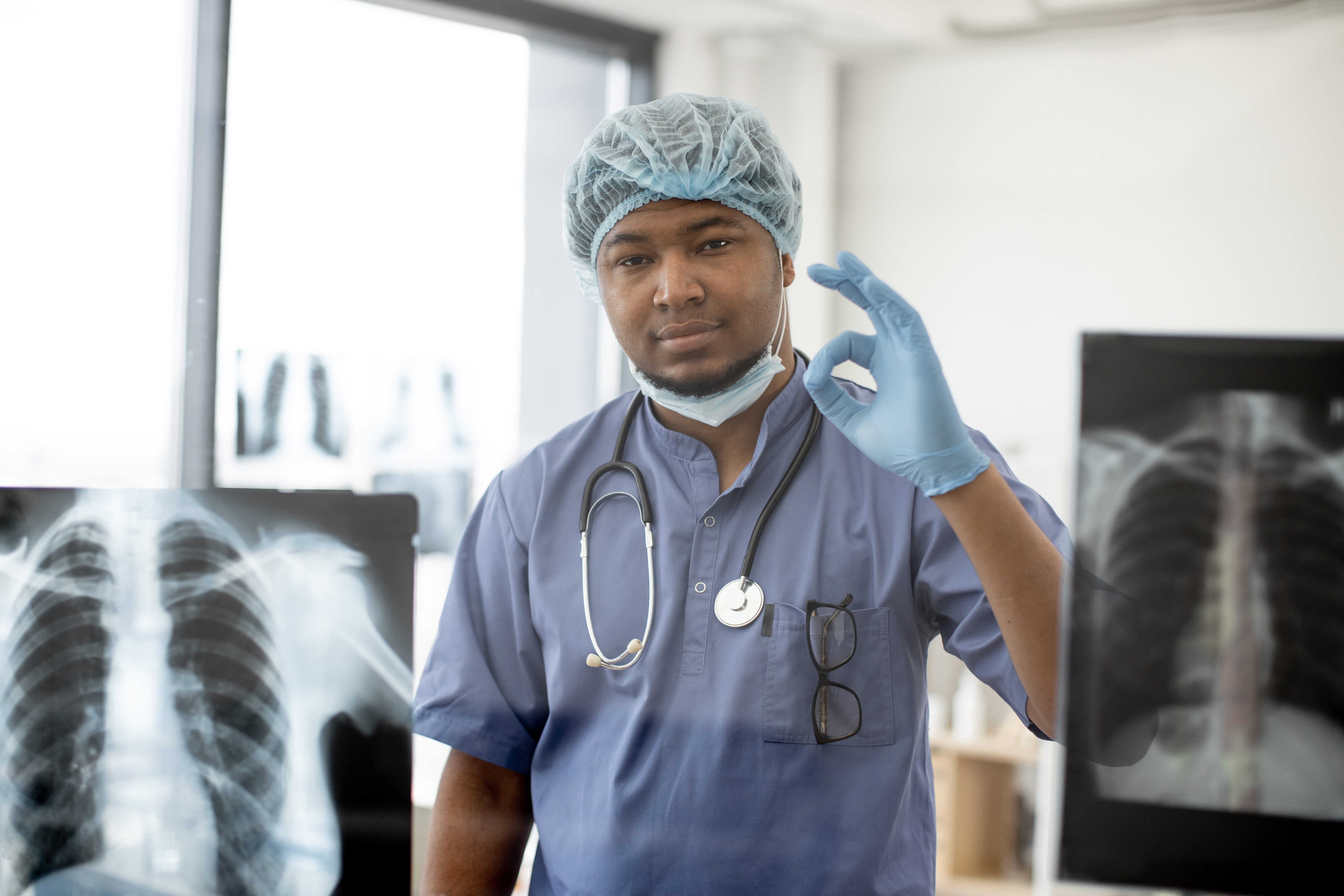 Surgeon showing thumb-up on X-ray scans